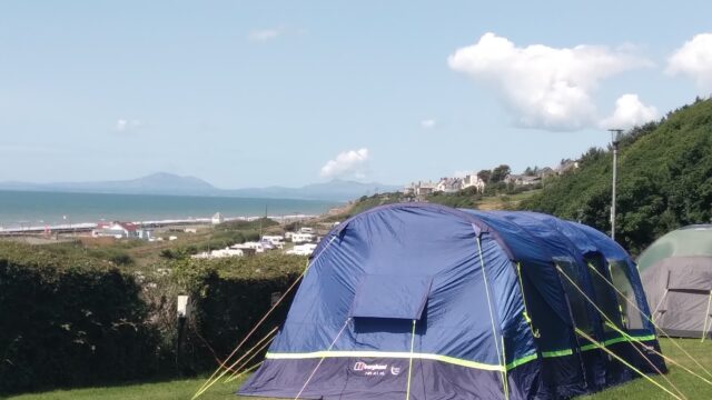 Close up of tents in a field overlooking the sea